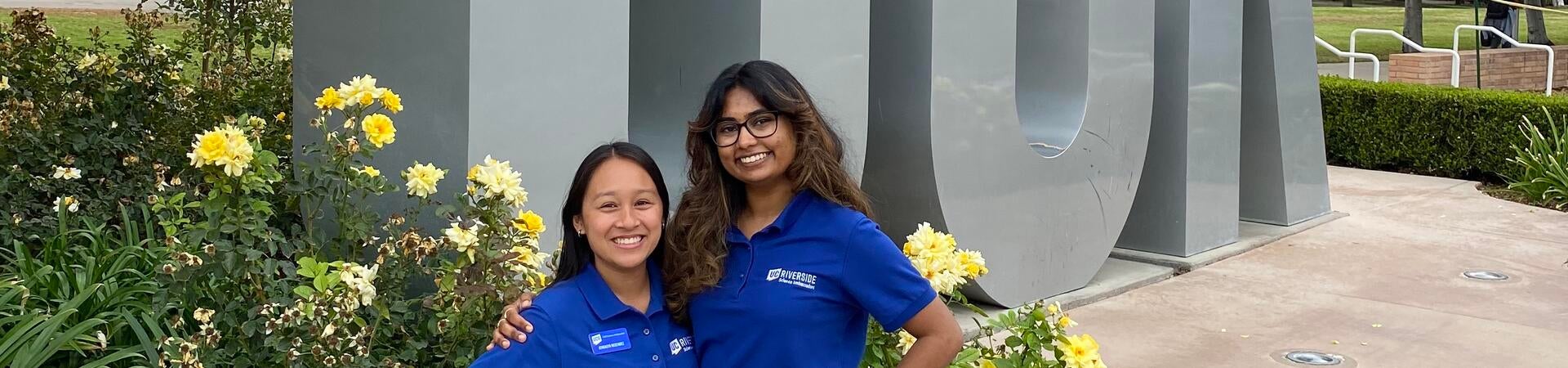 Jennalyn and Sonali in front of the UCR letters.